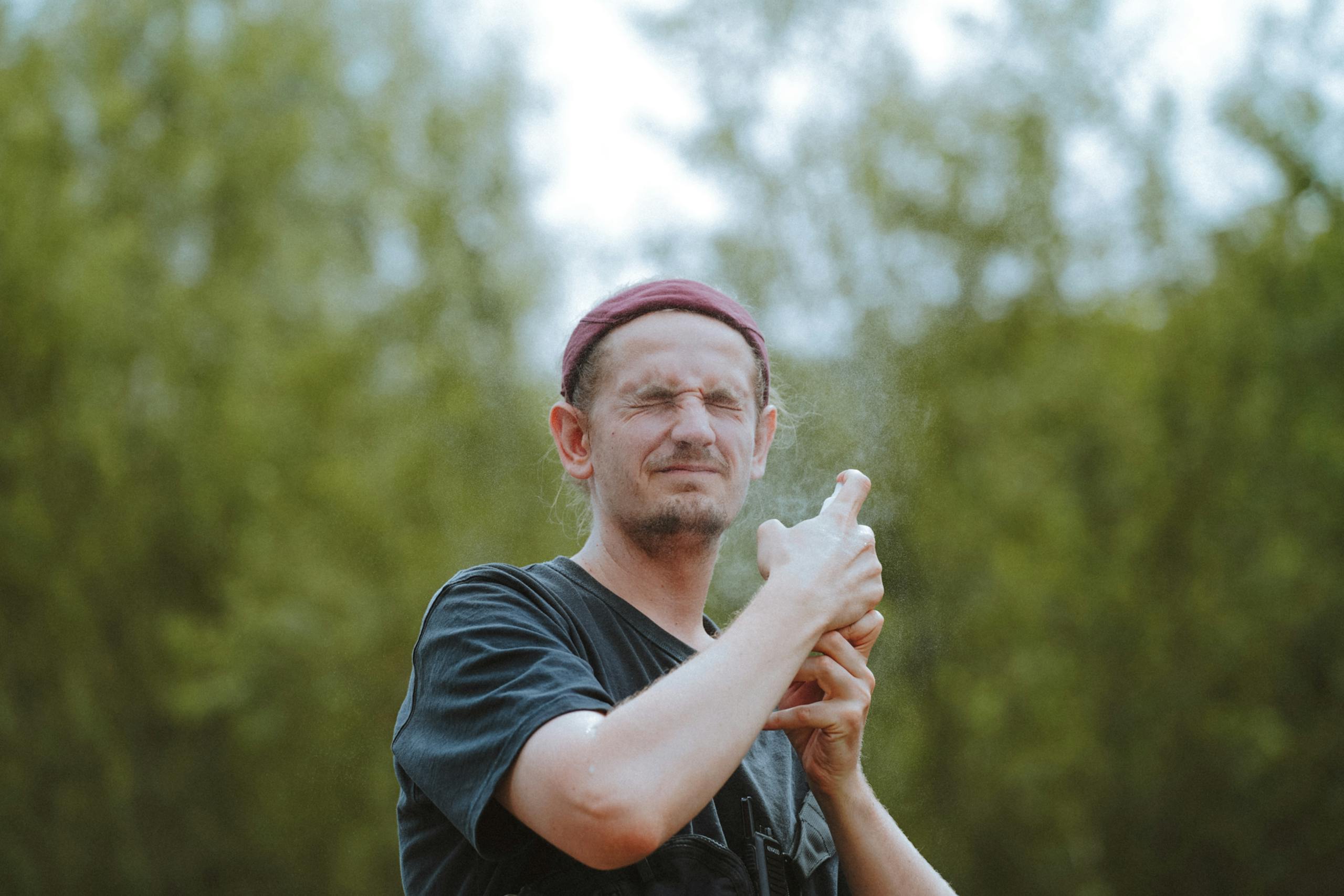 Man Spraying His Face Outdoors